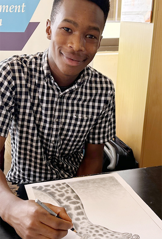Ezekiel Charles working on a giraffe drawing