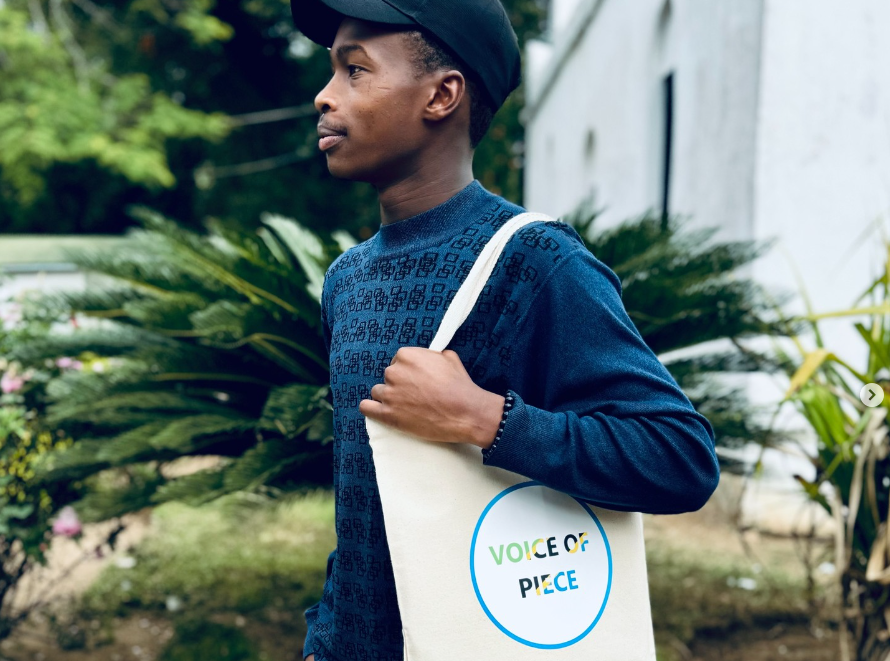 Ezekiel Charles carrying a Voice of Piece tote bag